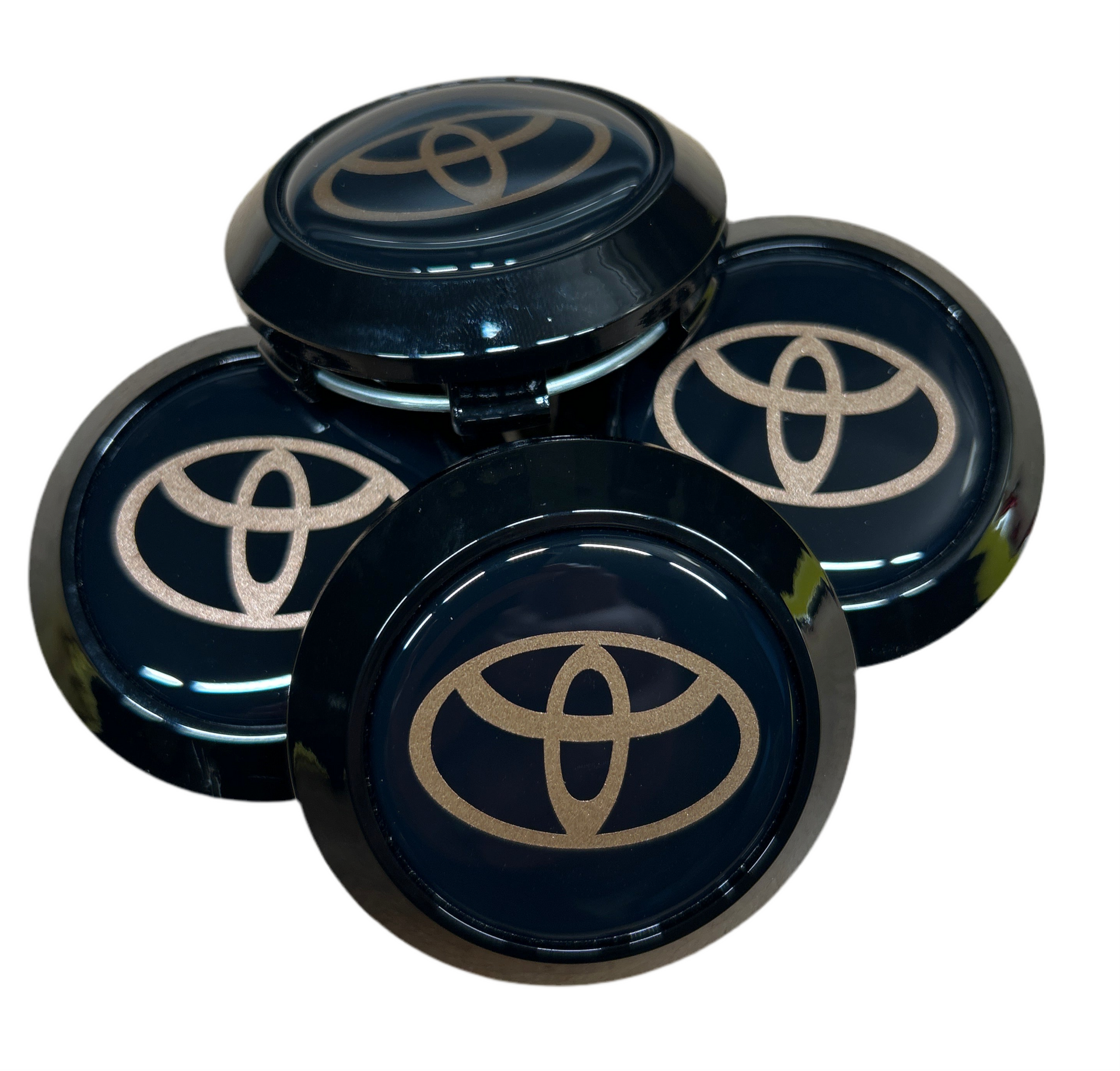 Four Toyota logo car wheel hub caps on a white background